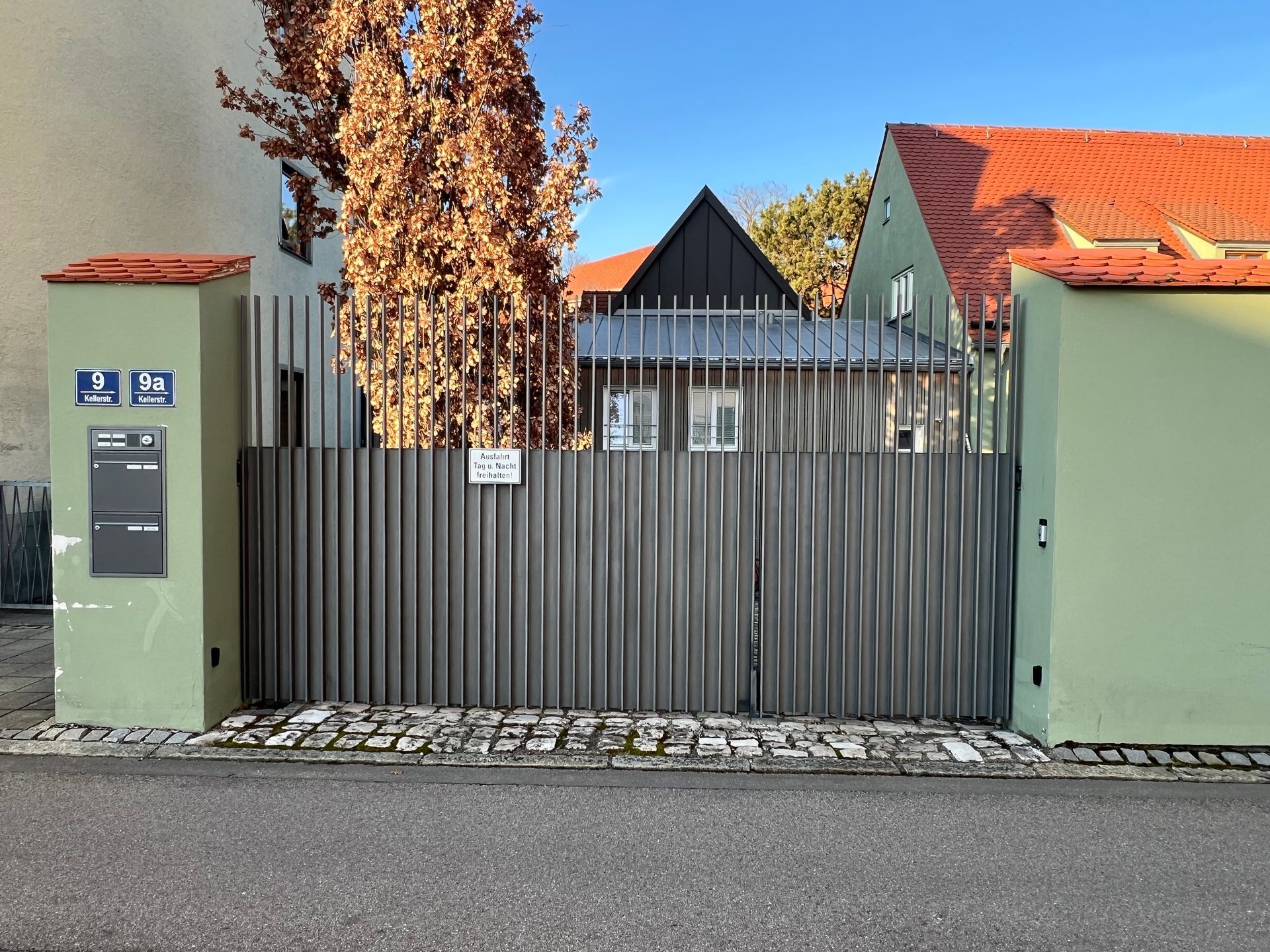 Ein Haus mit einem Zaun und einem Briefkasten davor