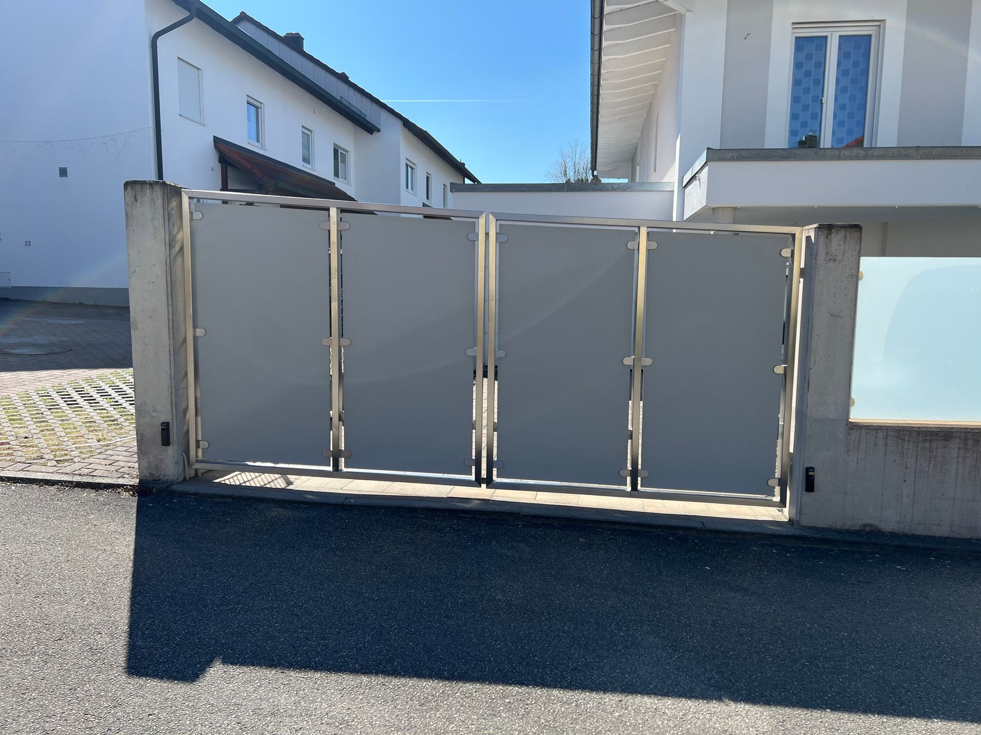 Ein weißes Haus mit einem Tor davor