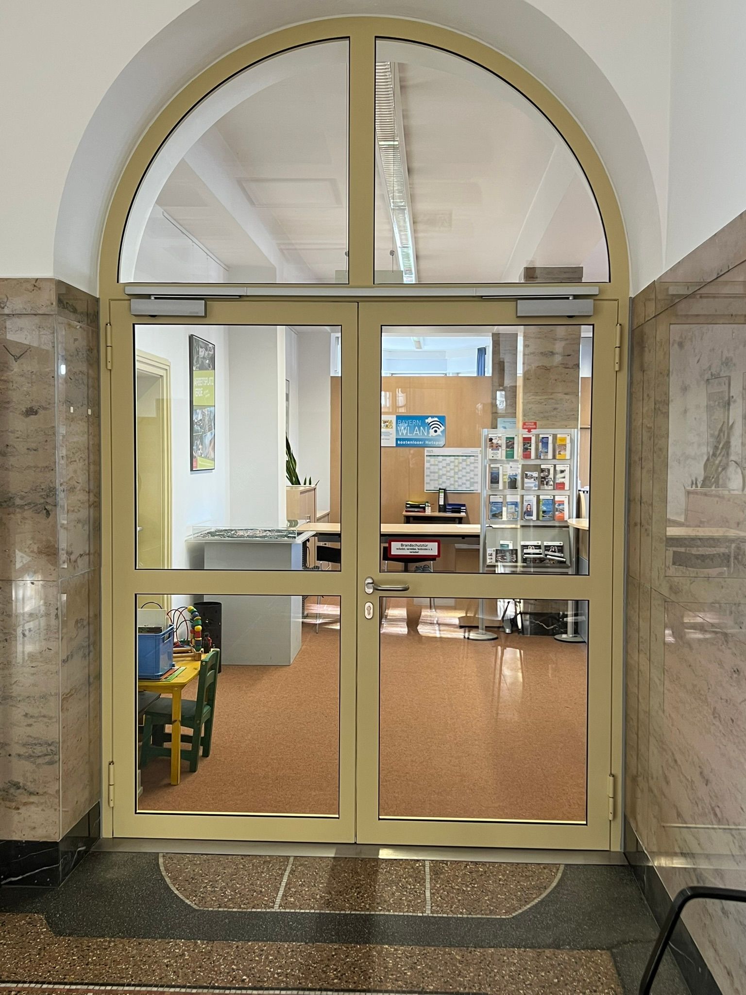 Eine Glastür, die zu einem Raum mit einem Tisch und Stühlen führt