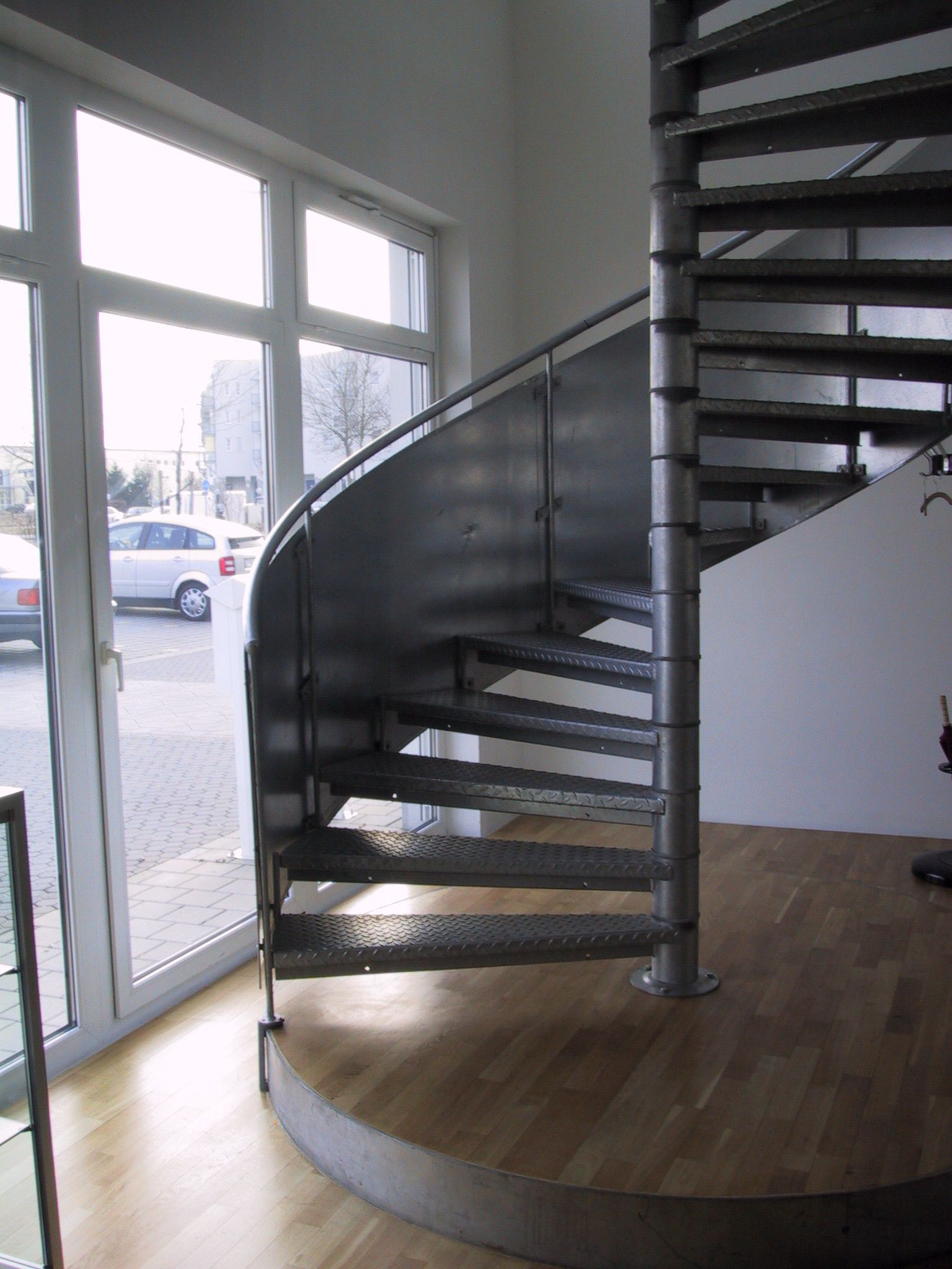 Eine Wendeltreppe in einem Raum mit vielen Fenstern