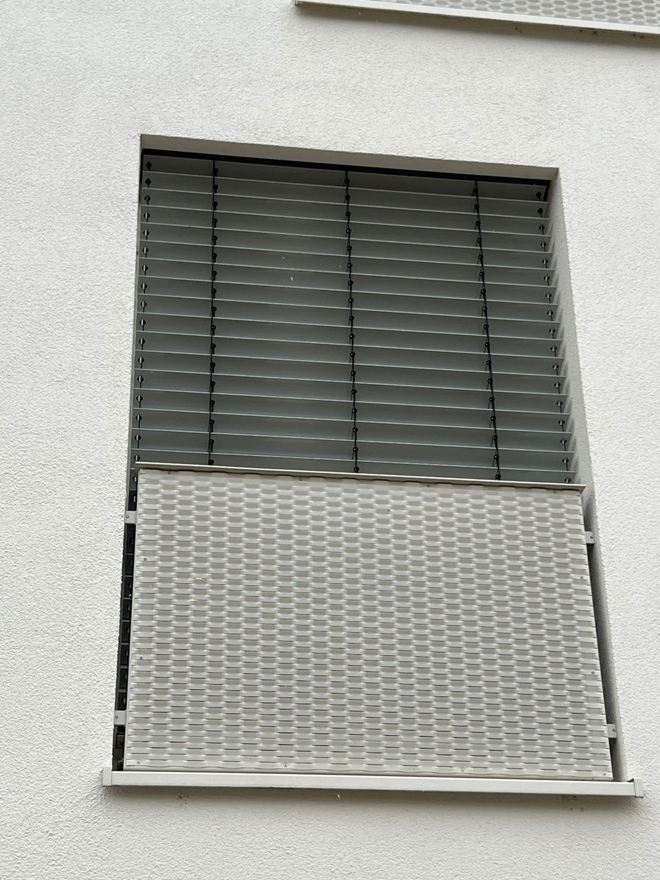Ein Fenster mit einem Metallgitter an der Seite