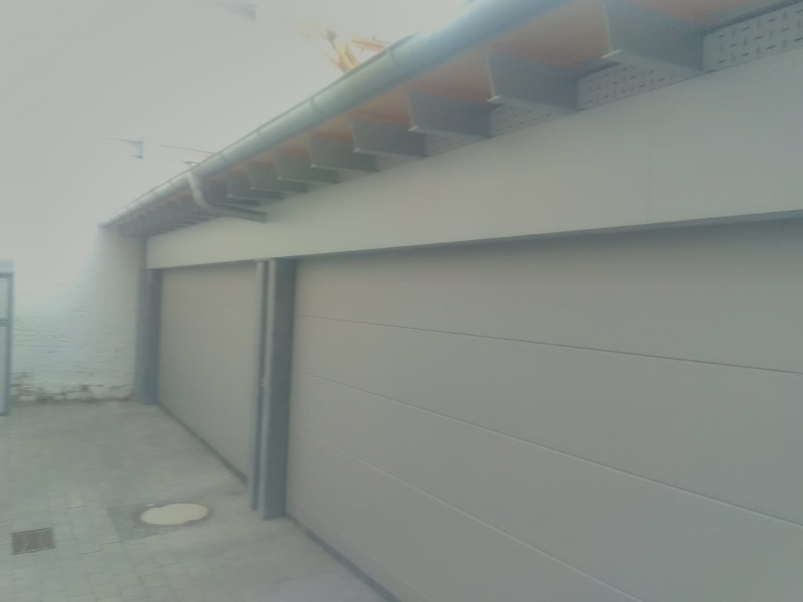 Ein Garagentor mit einer Dachrinne an der Seite.