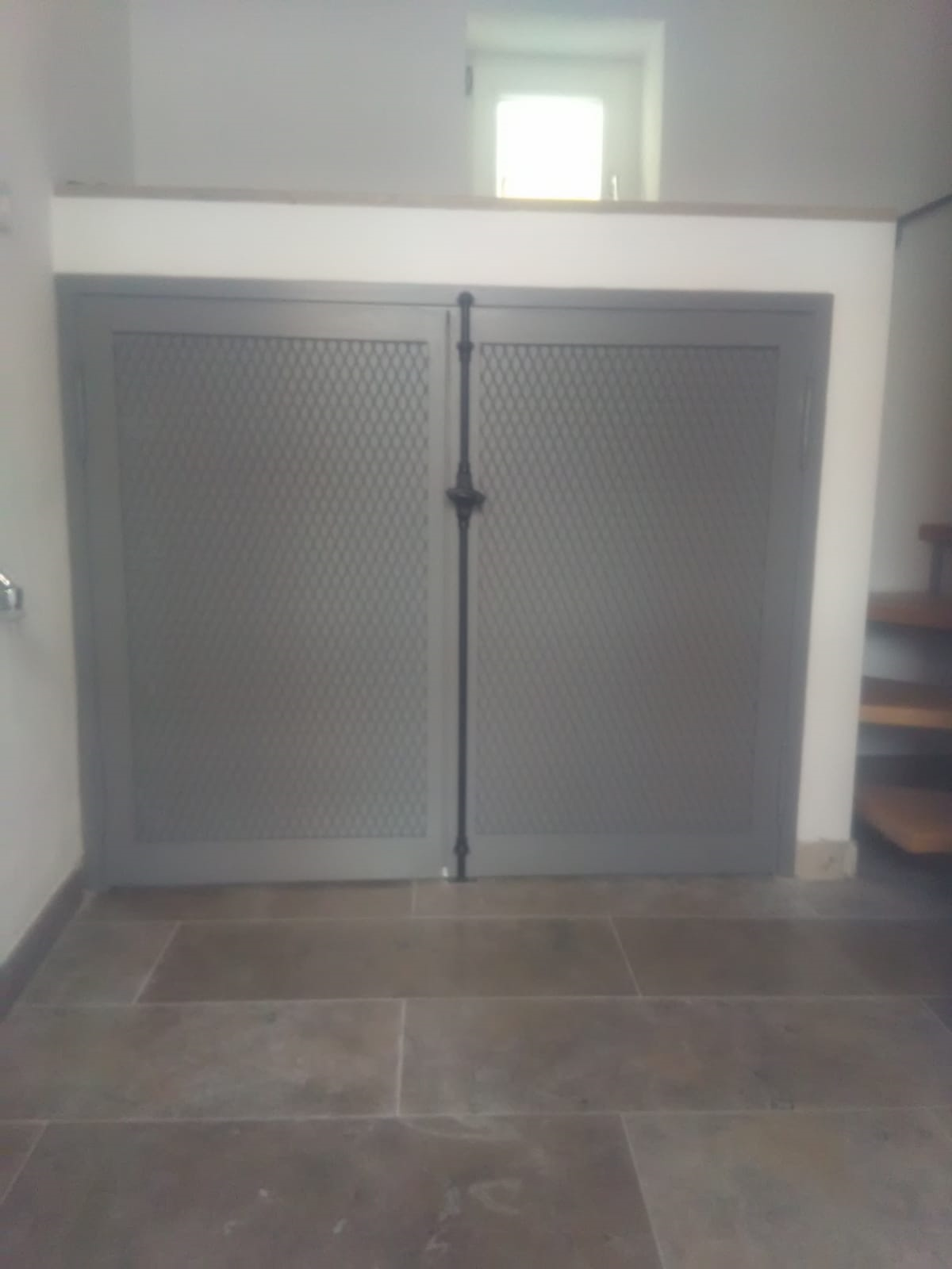 Ein Raum mit einer Treppe und einer grauen Tür