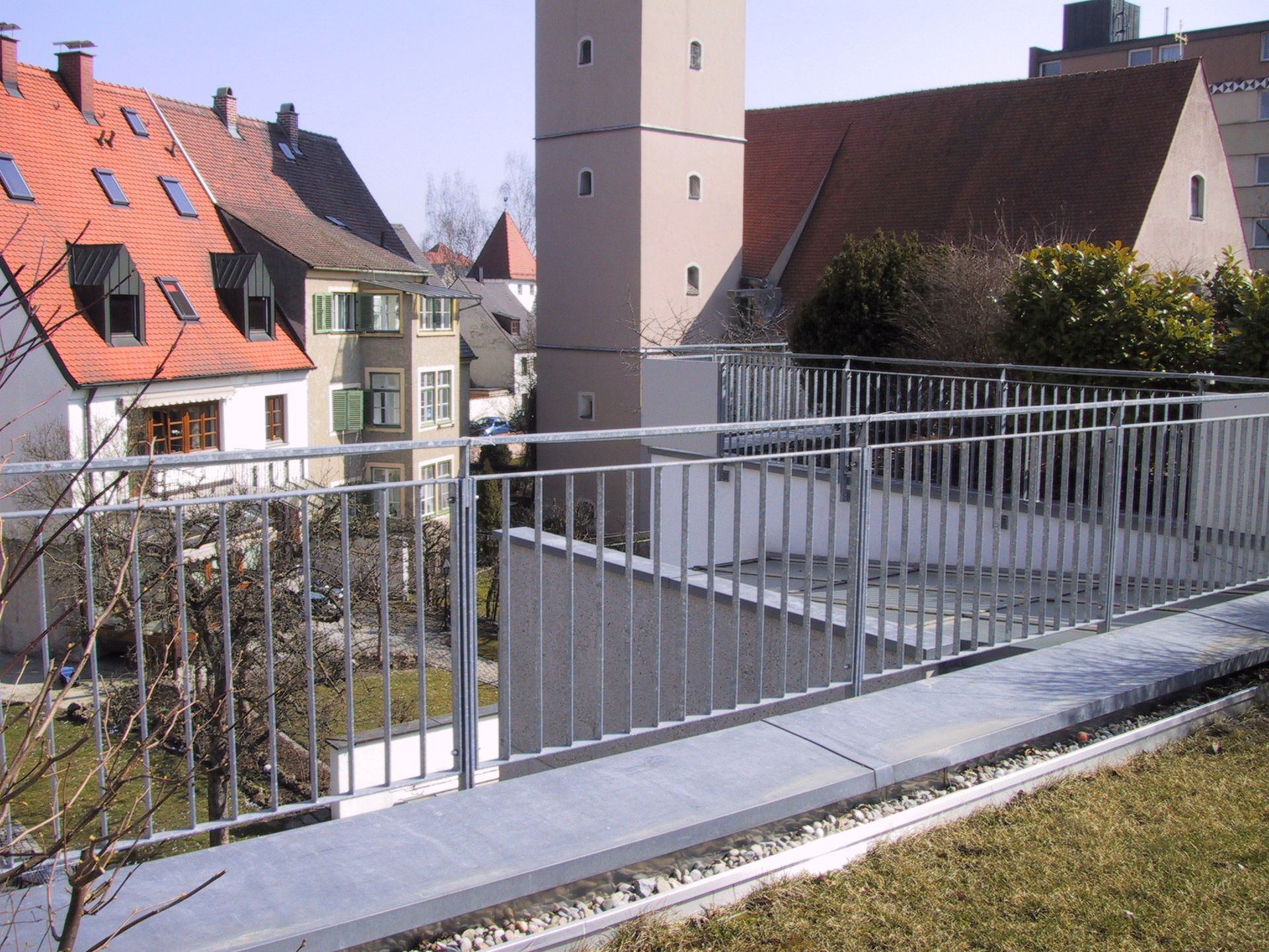 Ein Metallgeländer mit einem Turm im Hintergrund