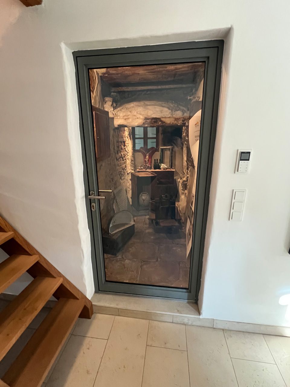 Eine Tür in einem Raum, zu der eine Treppe hinaufführt.