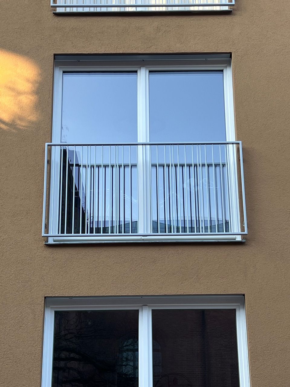 Ein Gebäude mit drei Fenstern und einem Balkon