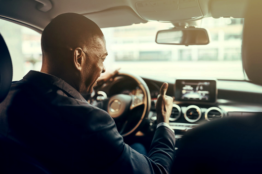 Chauffeur souriant devant son volant