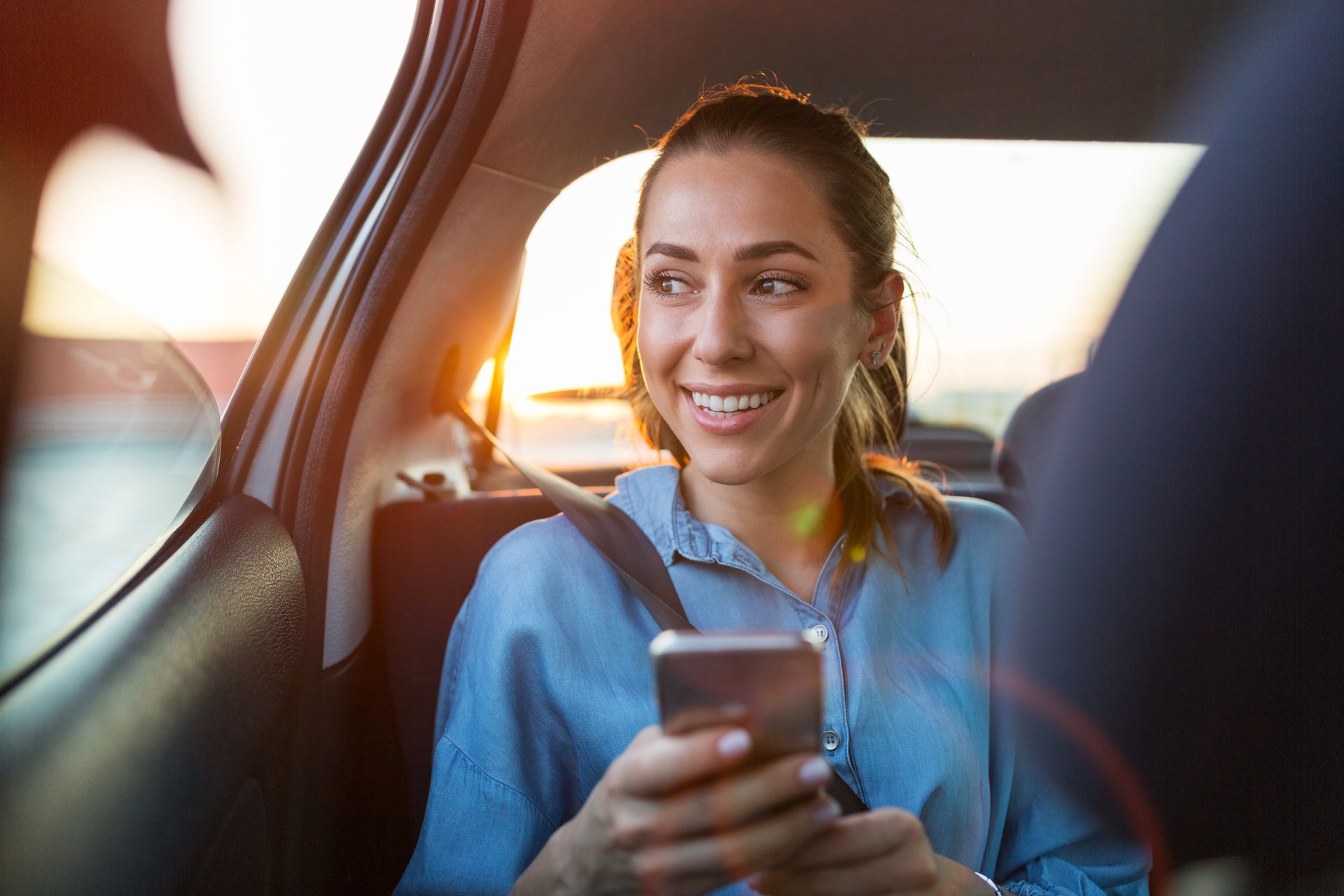 Une femme qui sourit à l'arrière d'un taxi