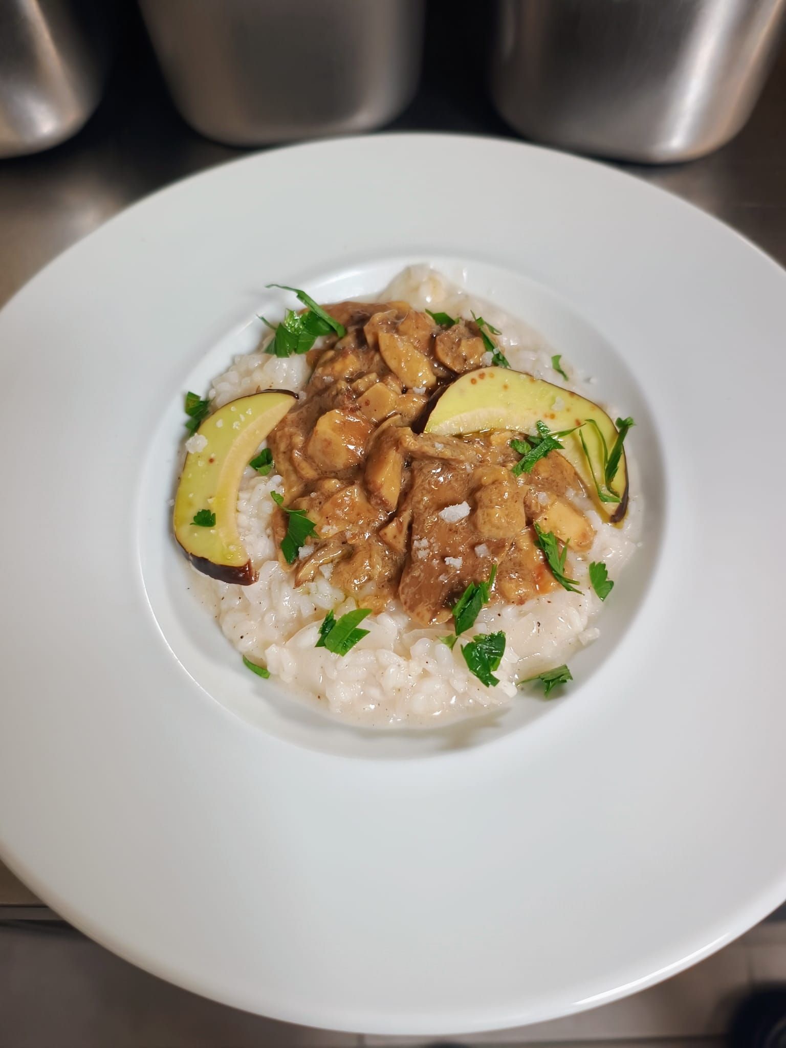 Bol de riz avec poulet glacé, tranches d'avocat et herbes aromatiques sur une assiette blanche