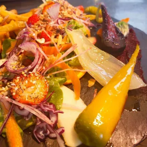 Salade composée avec légumes rôtis, poivrons jaunes, oignons, carottes.