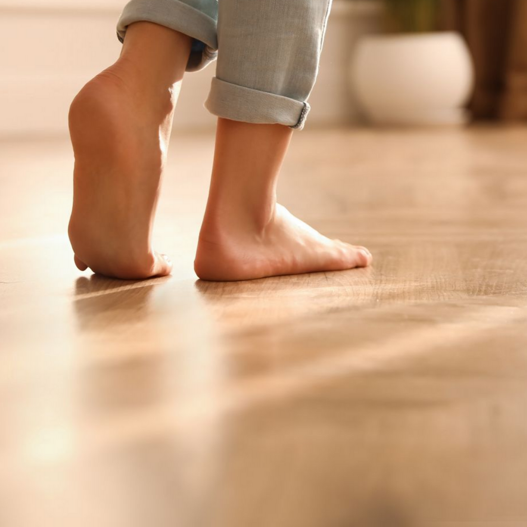 Pieds nus sur un parquet.