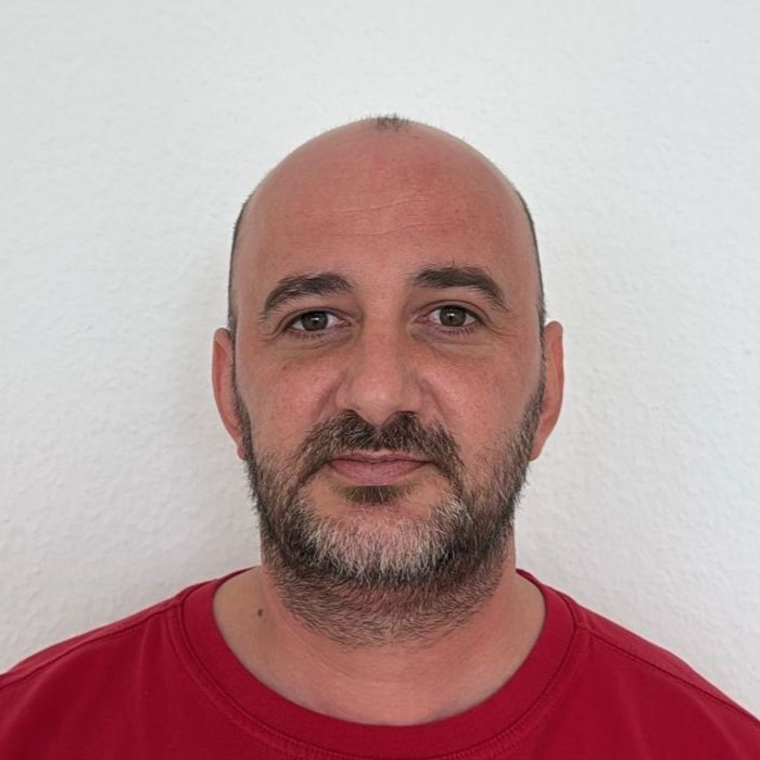 Ein Mann mit Brille und rotem Hemd steht in einem Kreis