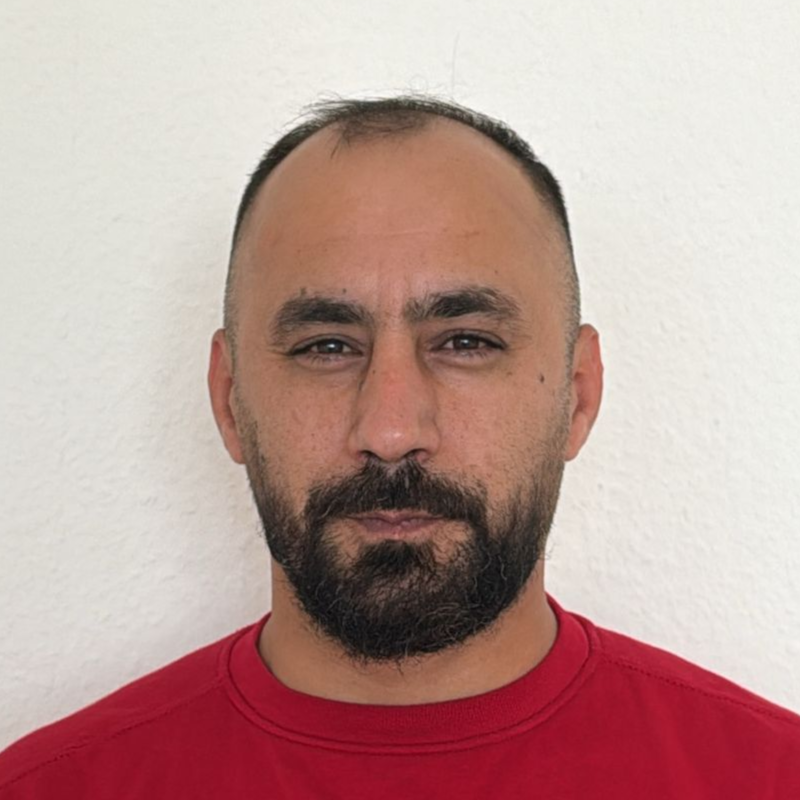 Ein Mann mit Bart trägt ein rotes Hemd