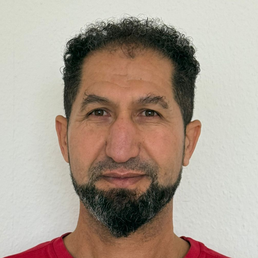 Ein Mann mit Brille und rotem Hemd steht in einem Kreis