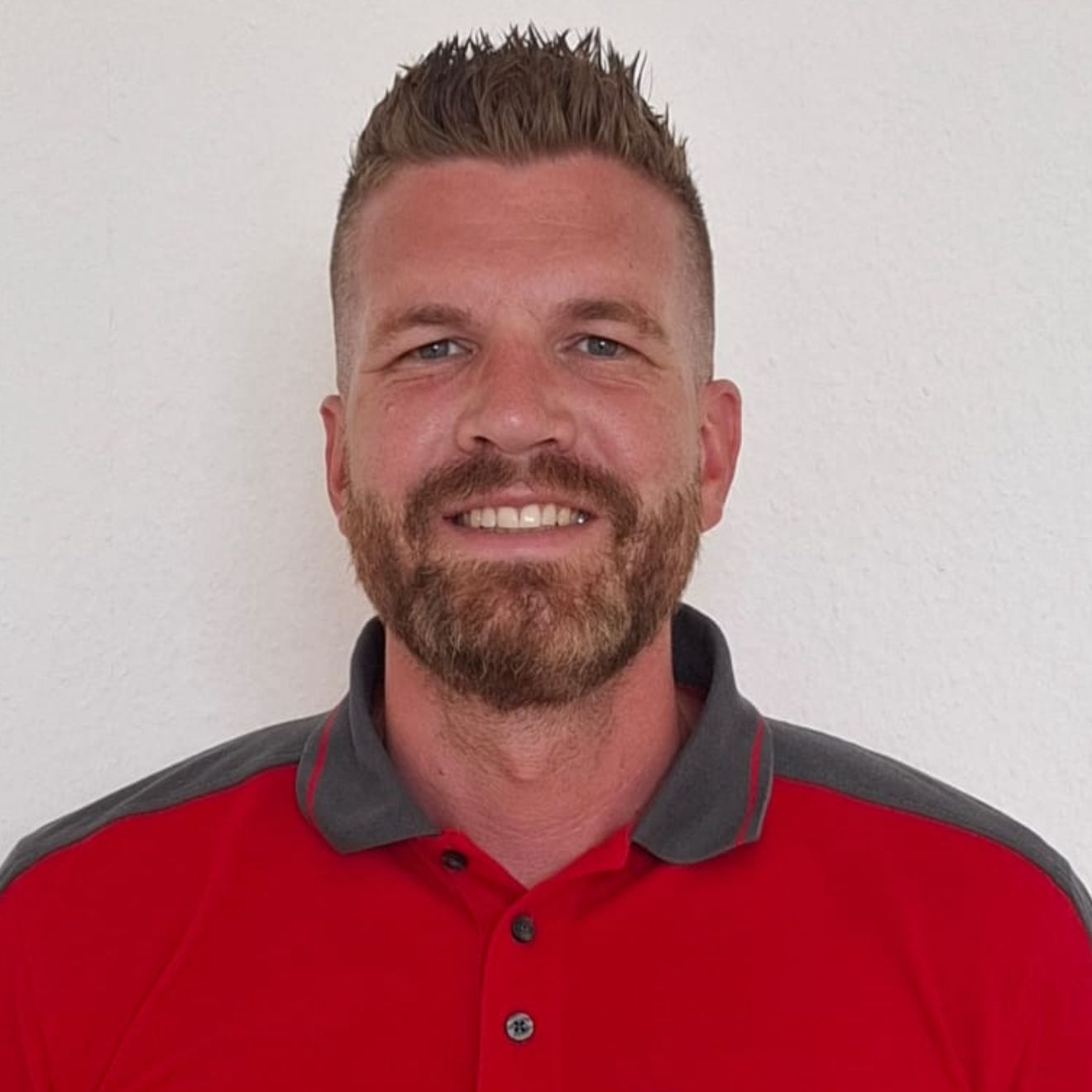 Ein Mann mit Brille und rotem Hemd steht in einem Kreis
