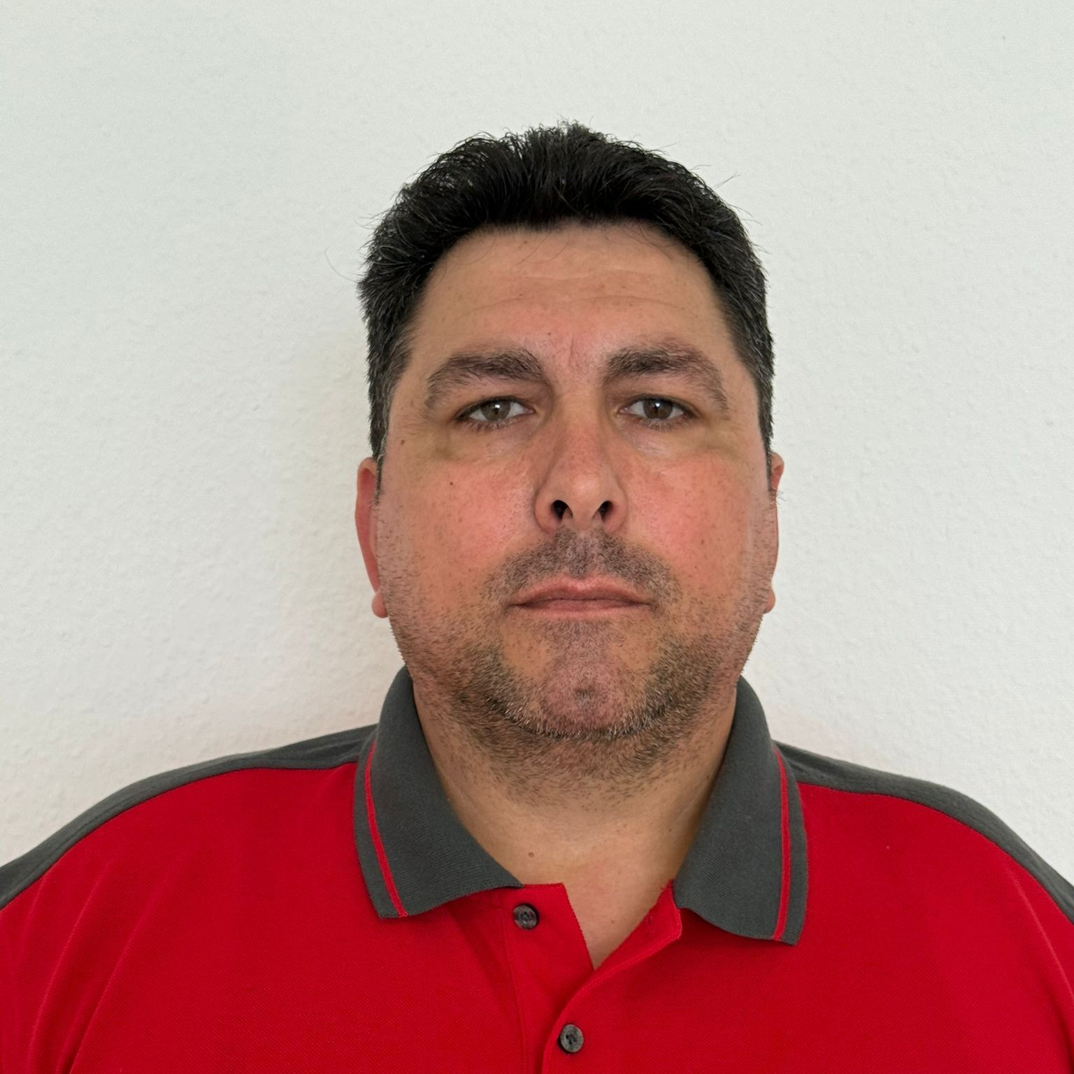 Ein Mann mit Bart trägt ein rotes Hemd
