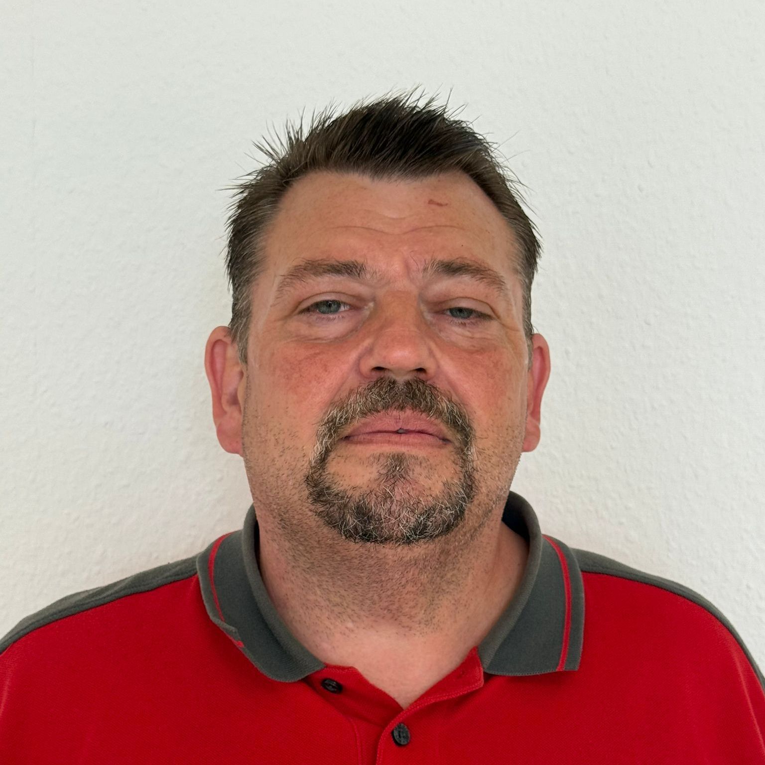 Ein Mann mit Brille und Bart lächelt in einem Kreis