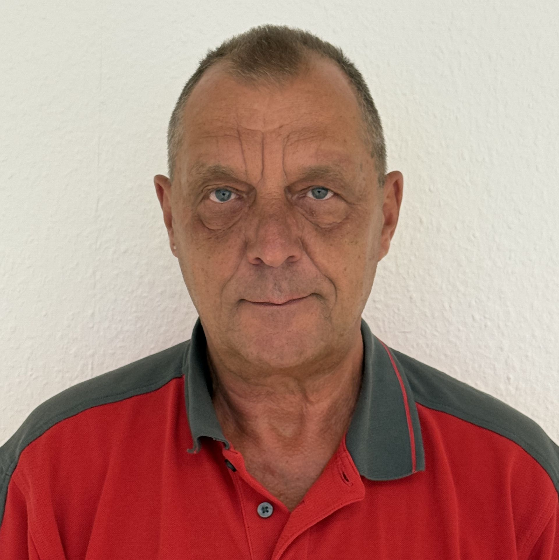 Ein Mann mit Brille und rotem Hemd steht in einem Kreis