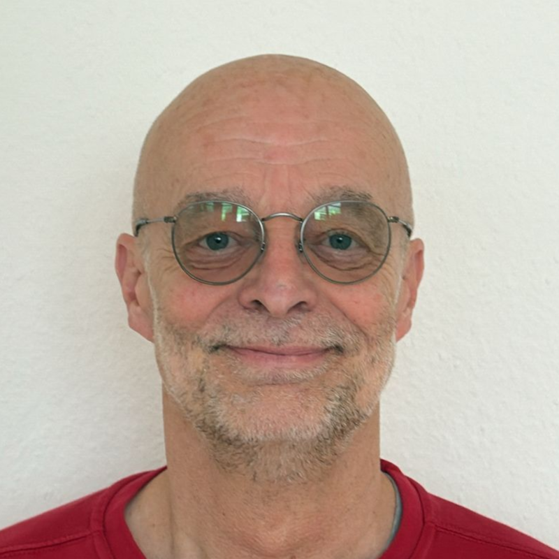 Ein Mann mit Brille und rotem Hemd steht in einem Kreis