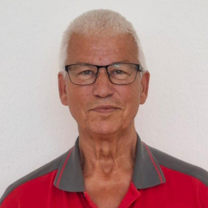 Ein Mann mit Brille und rotem Hemd steht in einem Kreis