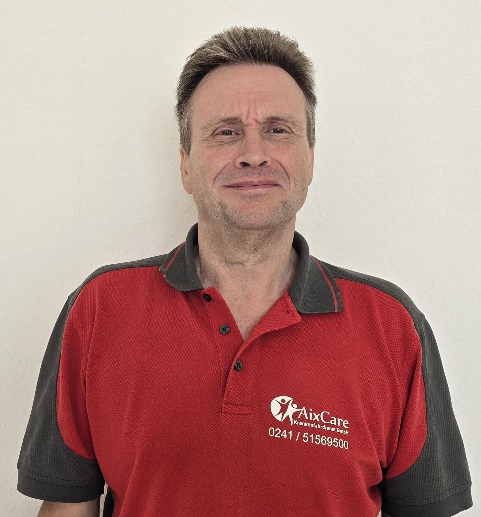 Ein Mann in einem roten Pullover lächelt in einem Kreis