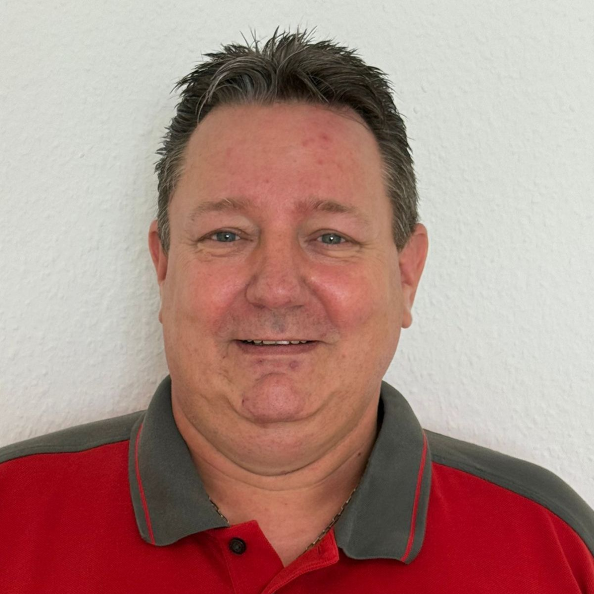 Ein Mann mit Brille und rotem Hemd steht in einem Kreis