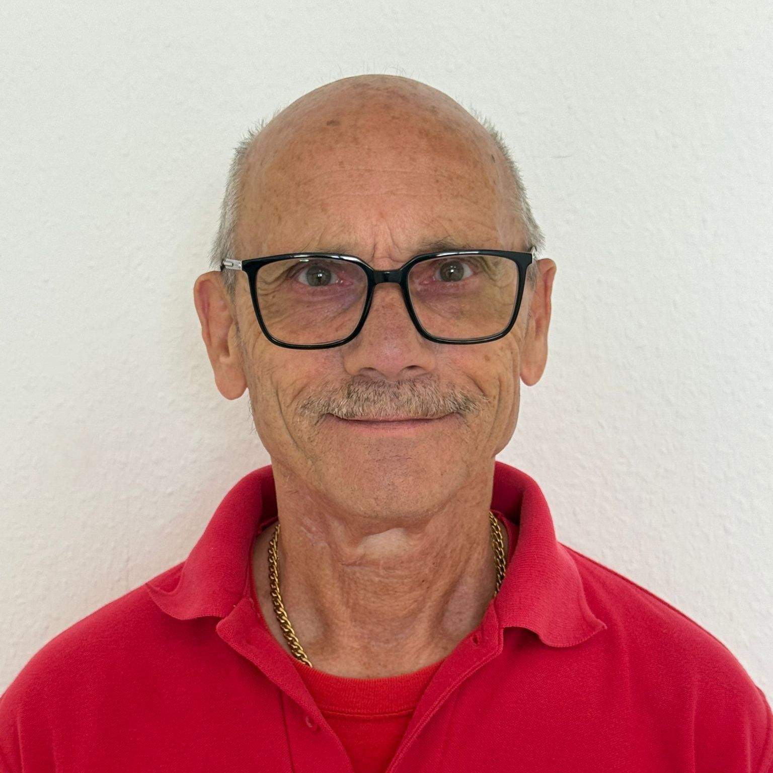 Ein Mann mit Bart trägt ein rotes Hemd