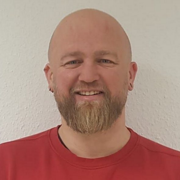 Ein Mann mit Bart trägt ein rotes Hemd