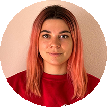 Eine Frau mit rosa Haaren trägt einen roten Pullover