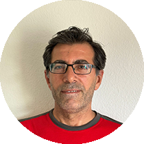 Ein Mann mit Brille und rotem Hemd steht in einem Kreis