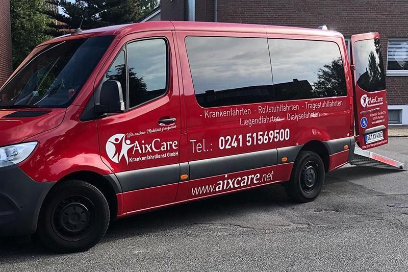 Ein roter Mixcare-Van steht vor einem Gebäude