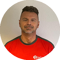 Ein Mann mit Bart trägt ein rotes T-Shirt mit der Aufschrift „abc“