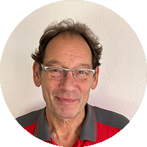 Ein Mann mit Brille und rotem Hemd lächelt in die Kamera
