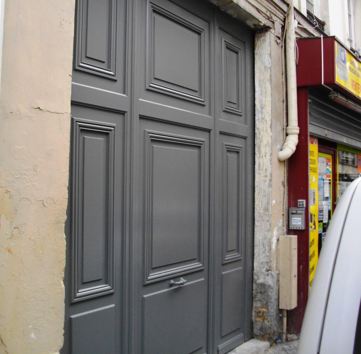 Porte cochère grise de biais