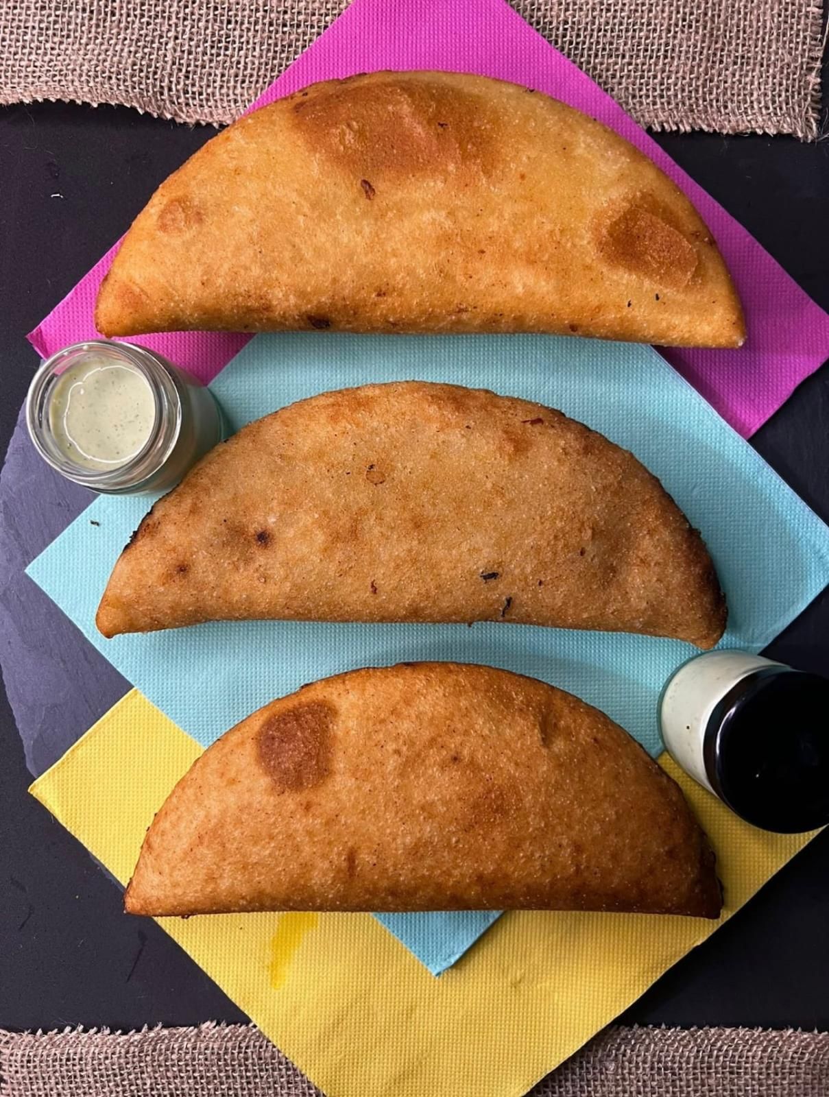 Tres pasteles en una servilleta de colores con salsa para mojar
