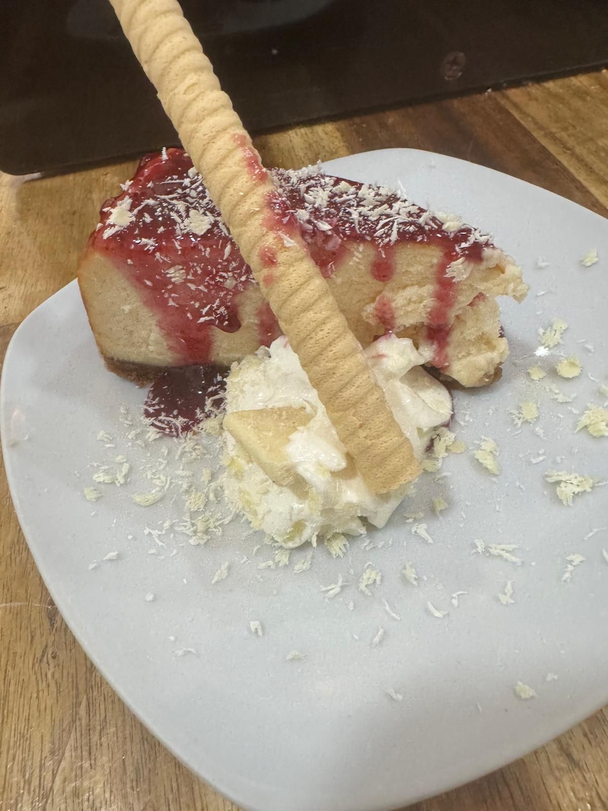 Un plato blanco cubierto con un trozo de pastel y crema batida.