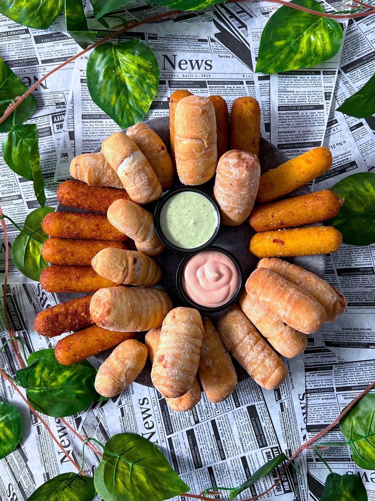 Una variedad de alimentos se encuentran encima de un periódico sobre una mesa.