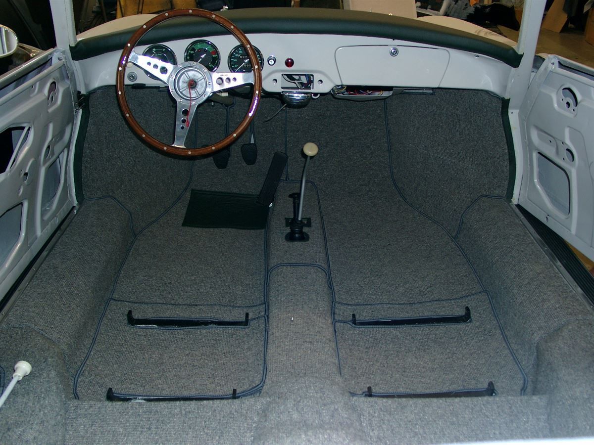 Der Innenraum eines weißen Autos mit einem Holzlenkrad