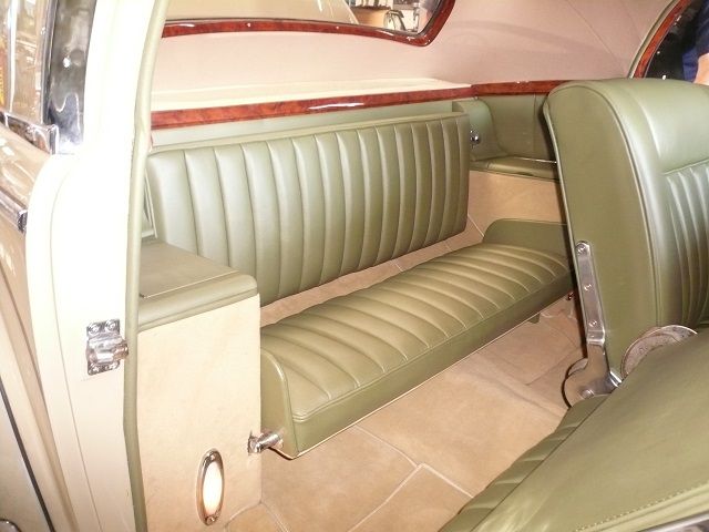 Der Rücksitz eines Autos mit grünen Ledersitzen