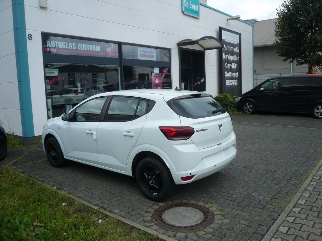 Ein weißes Auto steht vor einem Autohaus
