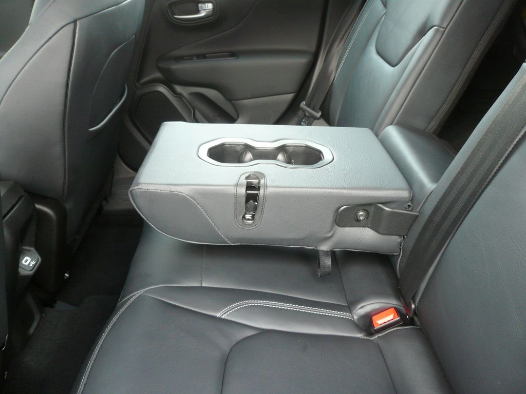 Der Rücksitz eines Autos hat einen Getränkehalter in der Armlehne