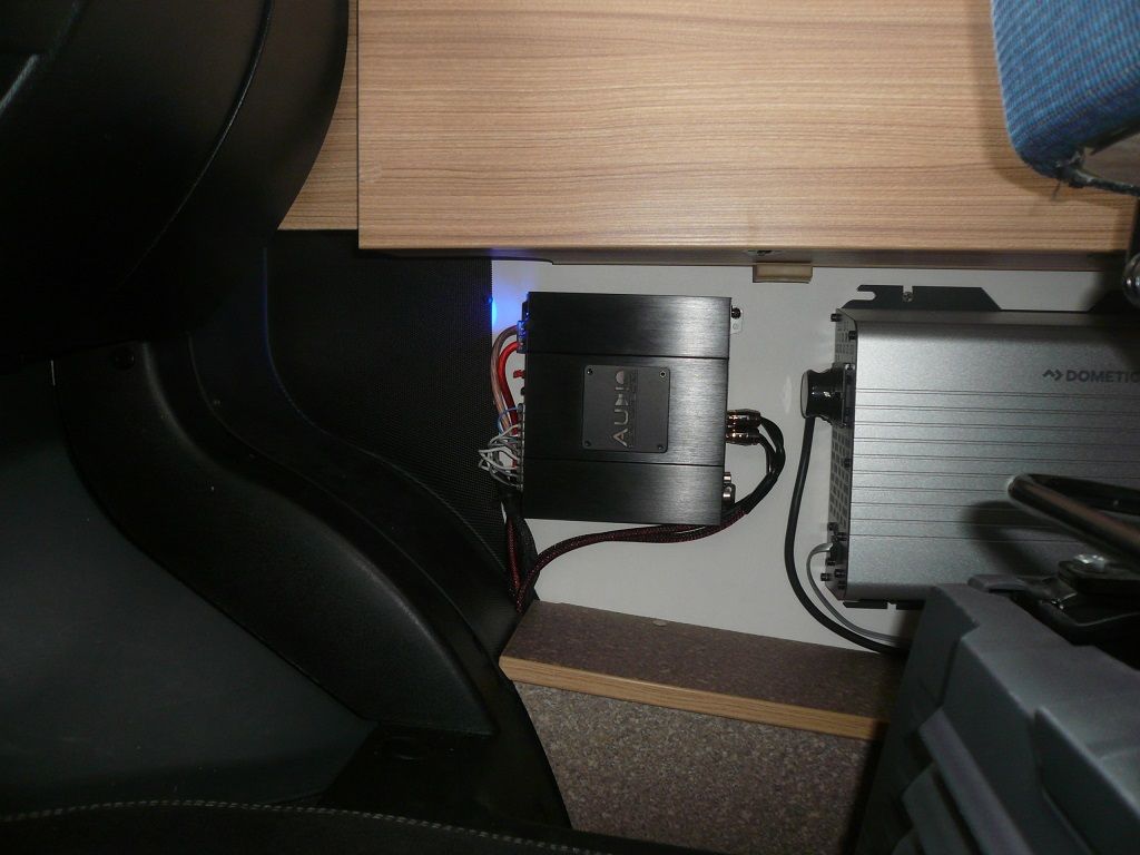 Ein Leistungsverstärker sitzt unter einem Holztisch