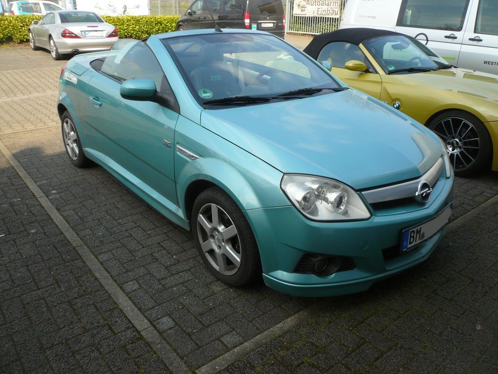 Ein blaues Cabrio steht neben einem gelben Auto