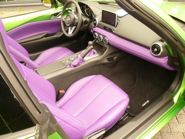 Der Innenraum eines grünen Autos mit violetten Sitzen