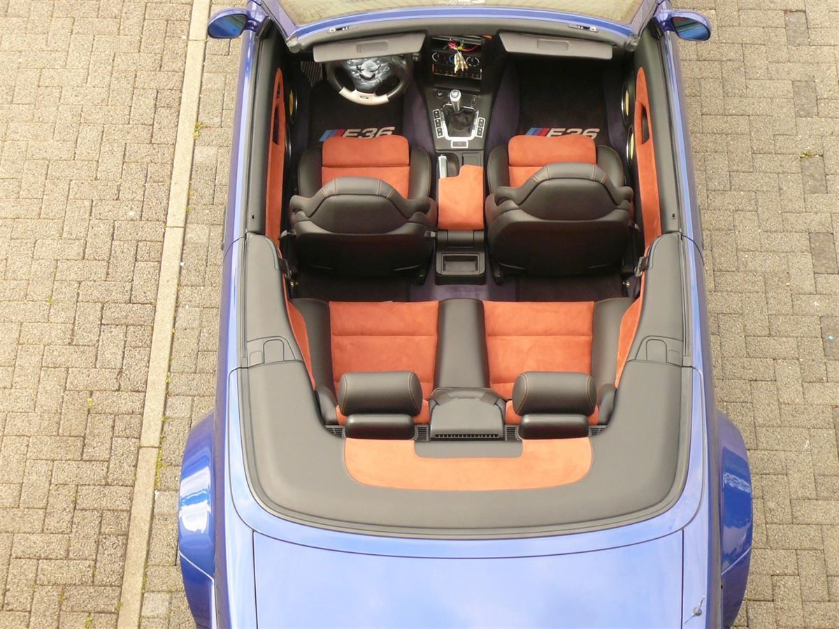BMW 3er E36 Cabrio Innenausstattung in Echtleder schwarz und Alcantara Terrakotta neu angefertigt und montiert. Logo auf Kundenwunsch in die Rückenlehnen eingestickt.