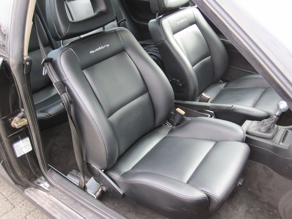 Schwarze Ledersitze in einem Auto mit dem Wort „Classic“ darauf