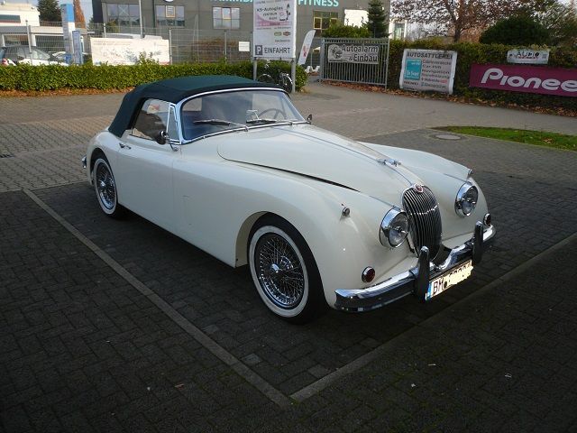 Ein weißes Auto steht vor einem Pionierschild