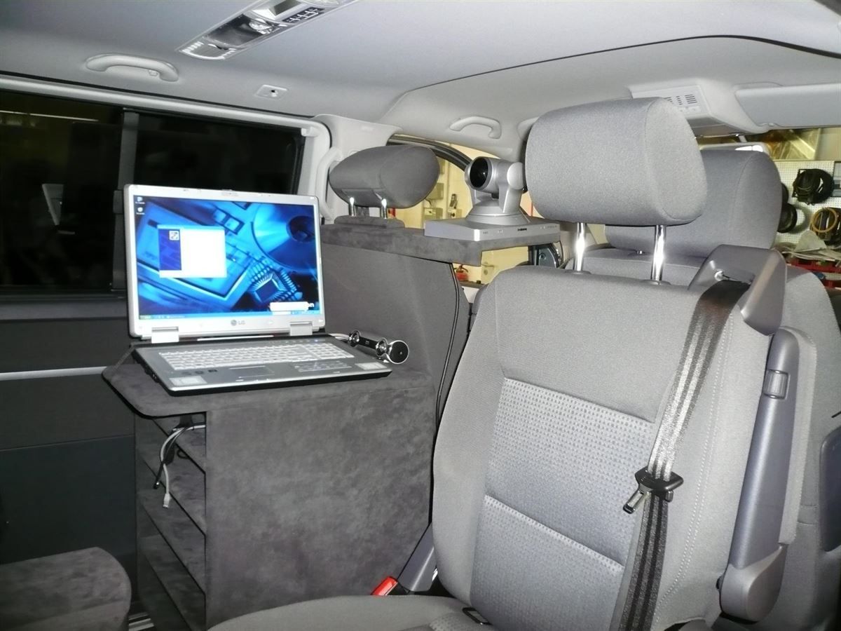 Ein Laptop liegt auf einem Tisch auf dem Rücksitz eines Autos