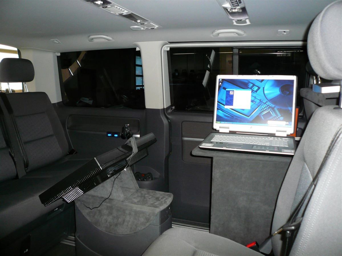 Ein Laptop liegt auf einem Tisch auf dem Rücksitz eines Autos