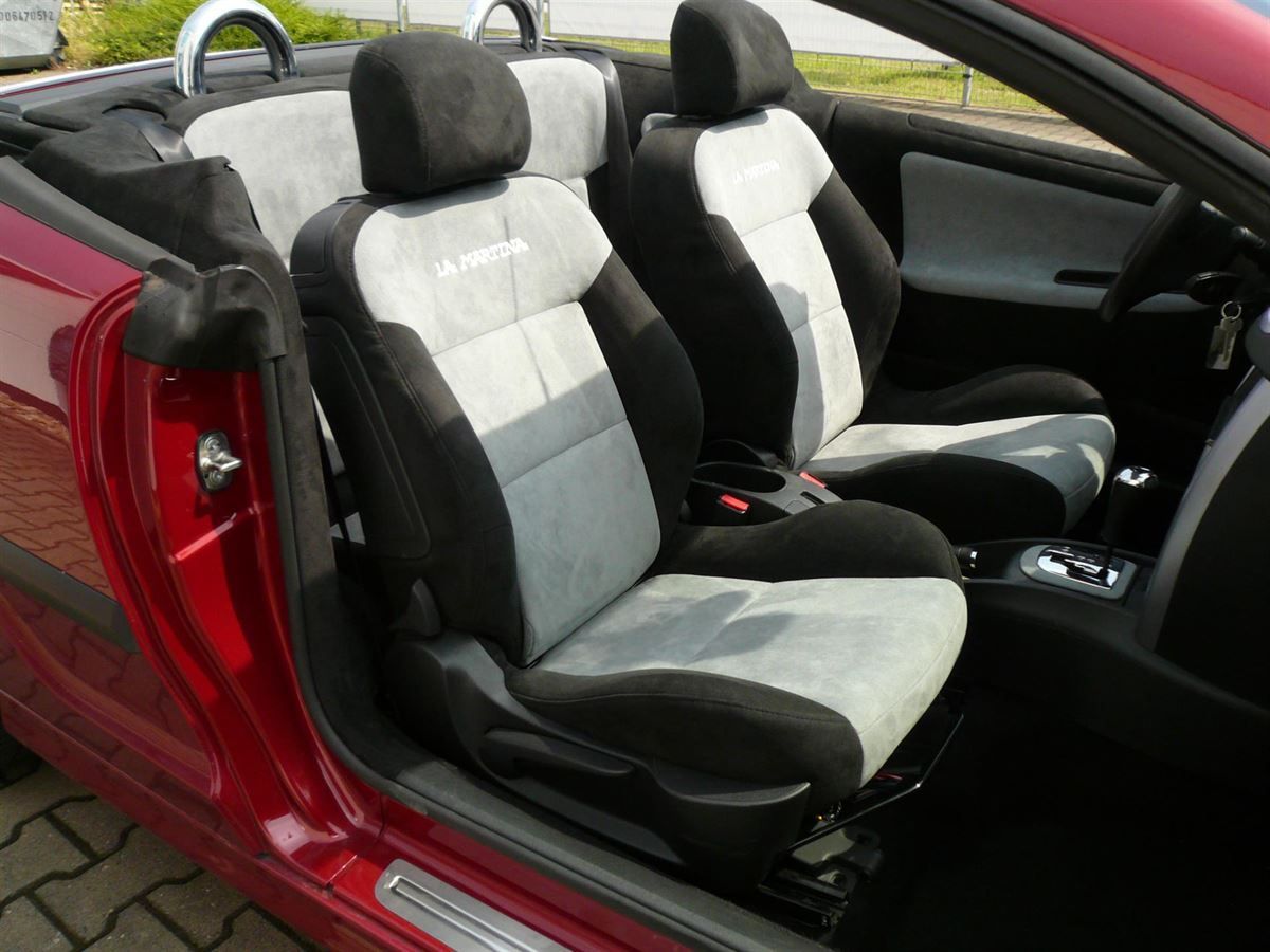 Ein rotes Auto mit Cabrioverdeck und grauen Sitzen